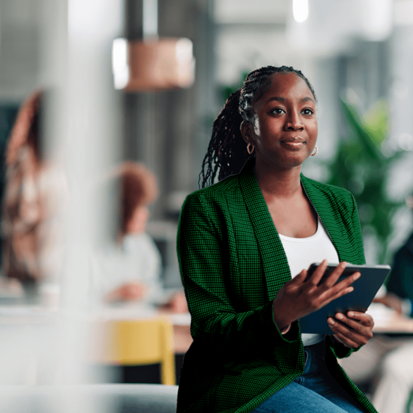 Professional woman in green blazer holding a tablet